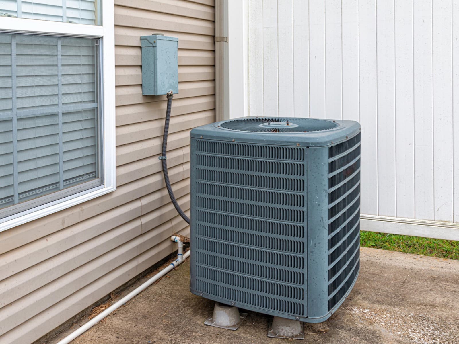 Air conditioning unit outside home on concrete.
